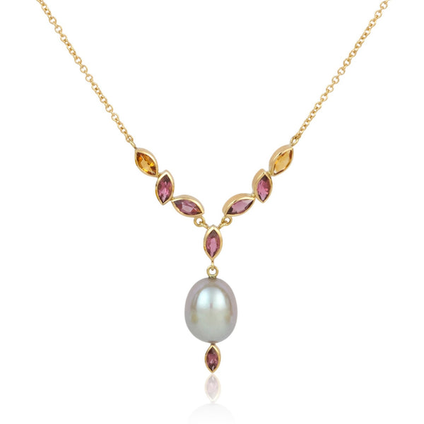 A photo on white of a gray pearl necklace on gold chain with a cascade of citrine, pink tourmaline and rhodolite garnets.